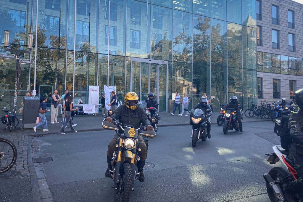 Szenenbild - Motoradfaher:innen - zu sehen sind 3 von 134 Fellows-Ride Motoradfahrer:innen beim eintreffen nach der Tour ab Beckum in Münster